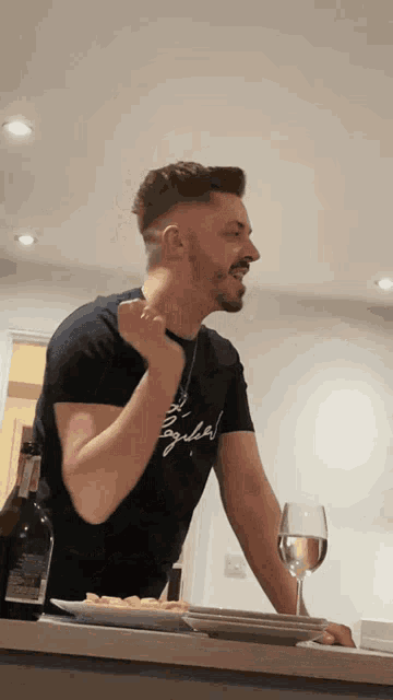a man wearing a tequila t-shirt holds his fist up