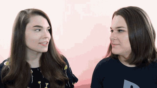 two girls are standing next to each other and one is wearing a shirt that says a on it
