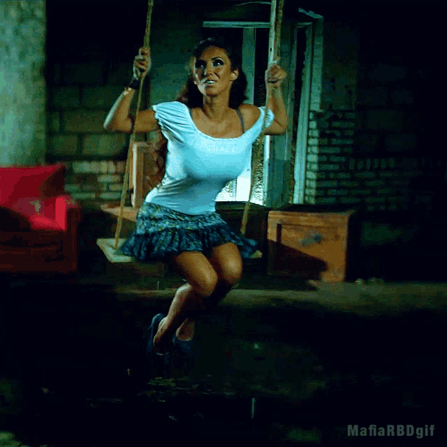 a woman is sitting on a swing with the mafia rbdgif written below her