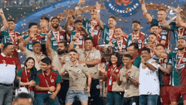 a group of soccer players are celebrating with confetti and a sign that says reliance star in the background