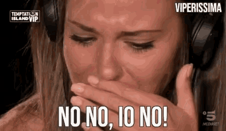 a woman wearing headphones is crying and saying no no io no !