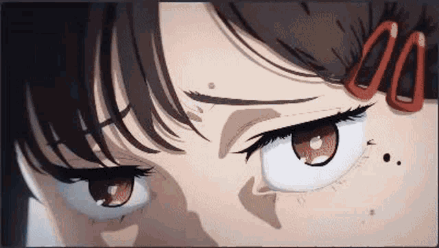 a close up of a girl 's eyes with red glasses on her forehead .