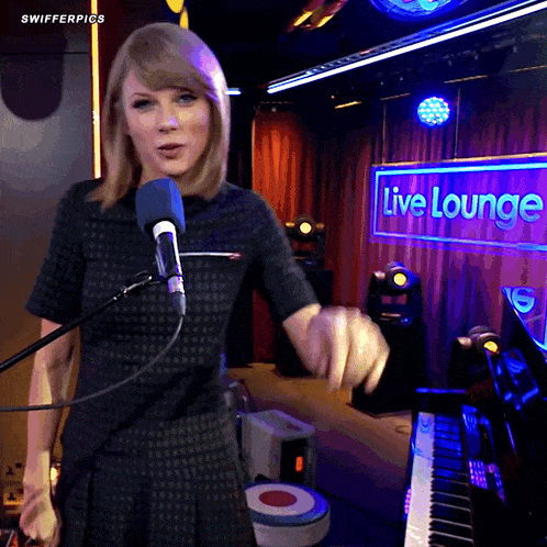 a woman singing in front of a live lounge sign