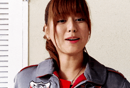 a woman wearing a gray jacket with a badge that says ' ucsd ' on it