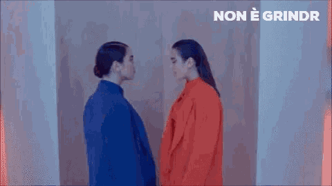 two women are kissing each other on the forehead in a room .
