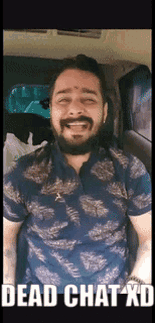 a man with a beard is sitting in a car with the text dead chat xd