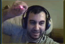 a man wearing headphones is smiling while playing a video game on a computer screen .