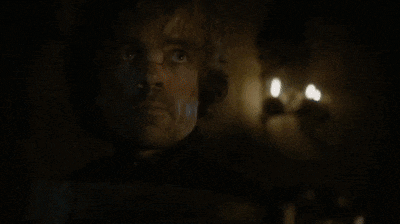 a close up of a man 's face in a dark room with a candle .