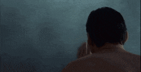 a man without a shirt is taking a bath in a bathtub .
