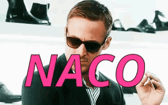 a man wearing sunglasses with the word naco written in pink