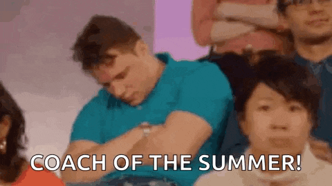 a man is sleeping in a crowd of people while a woman says `` coach of the summer '' .