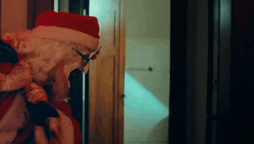 a man dressed as santa claus is standing in a doorway