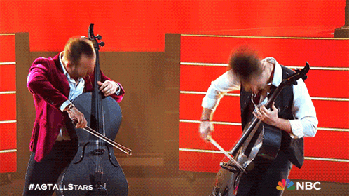 two men are playing cello in front of a nbc banner