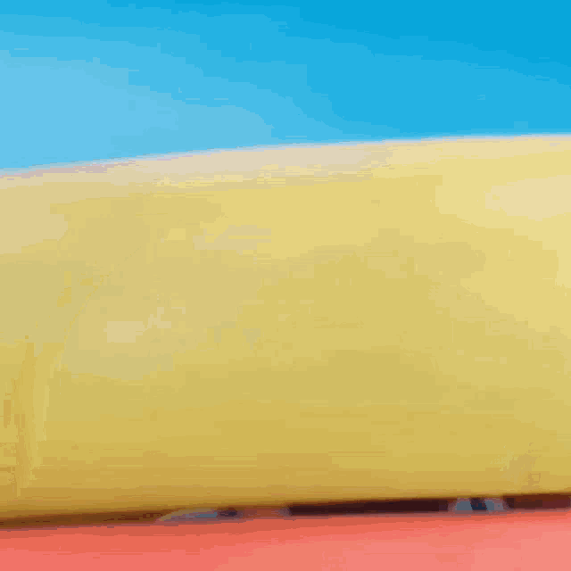 a man wearing a sombrero looks out from under a yellow object