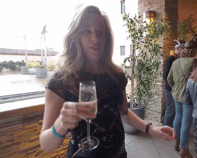 a woman is holding a glass of champagne in her hand