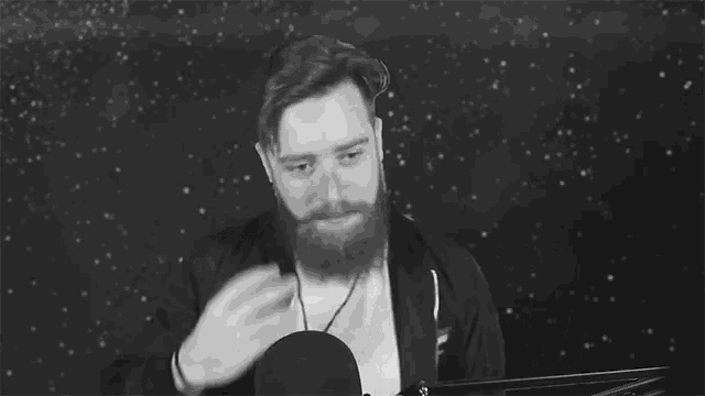 a black and white photo of a man with a beard and headphones