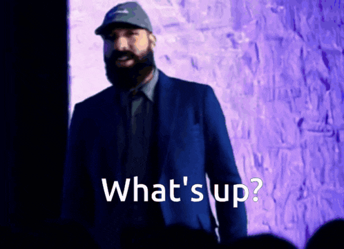a man in a suit says what 's up in front of a crowd