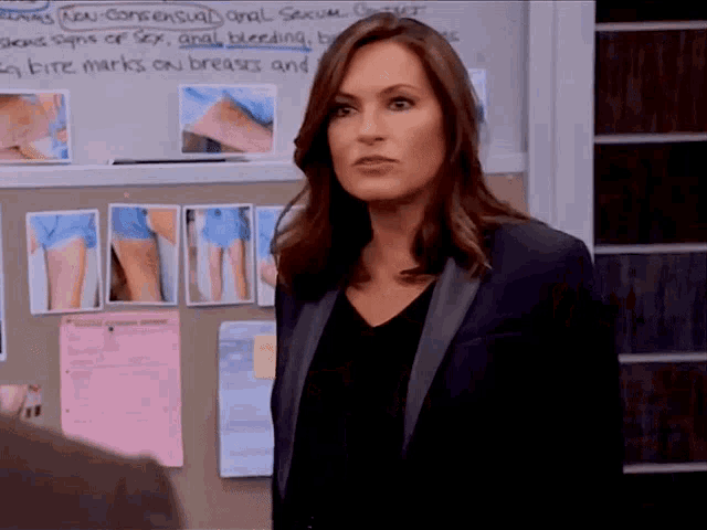 a woman stands in front of a bulletin board that says bite marks on breasts and anal bleeding