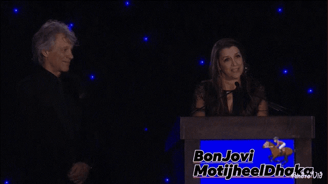 a man and a woman are laughing at a podium that says bon jovi