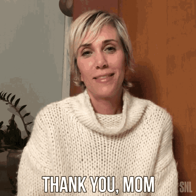 a woman in a white sweater is saying thank you mom