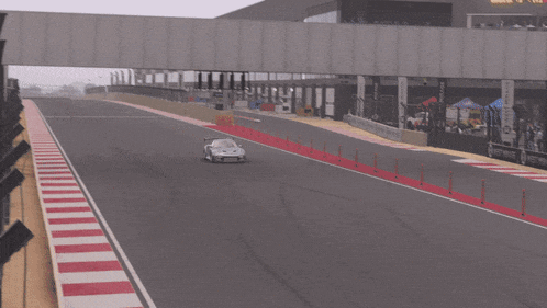 a gray sports car is driving down a street