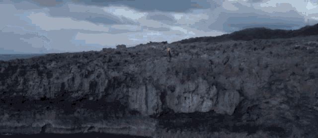 a person standing on top of a rocky hillside
