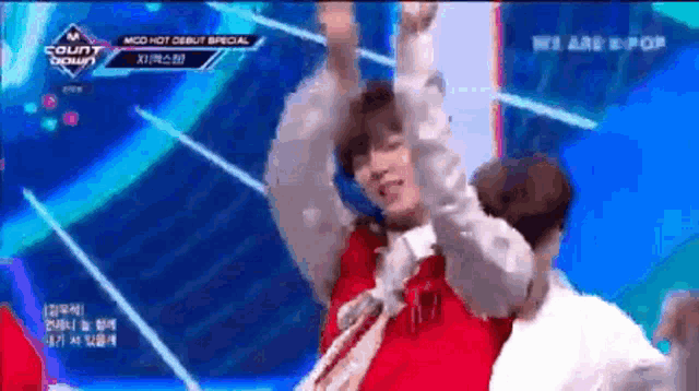 a man in a red shirt is dancing on a stage in front of a sign that says ' we are k pop '