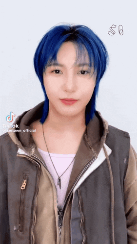 a young man with blue hair is wearing a jacket and a necklace