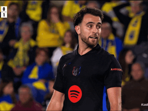 a man wearing a black shirt with a red spotify logo on the front