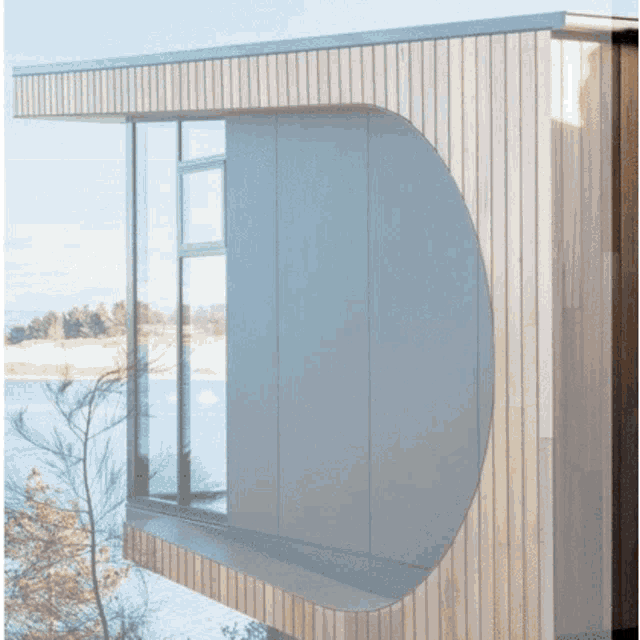 a house with a round window and a reflection of trees in the window