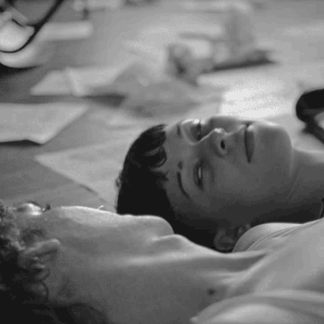 a black and white photo of a man and woman laying face down