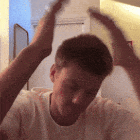 a man in a white t-shirt is raising his hands in the air