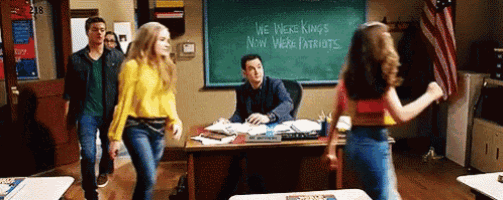 a group of people are standing in a classroom with a chalkboard that says we were kings now were patriots