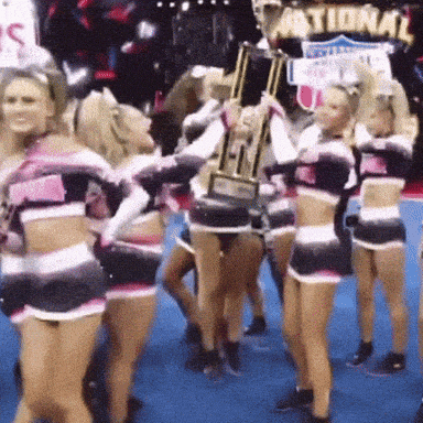 a group of cheerleaders are holding a trophy in front of a national sign