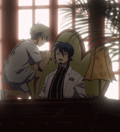a man in a white coat sits in a chair while another man stands next to him