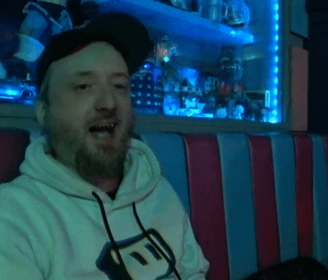 a man with a beard wearing a hat and a sweatshirt that says ' i ' on it