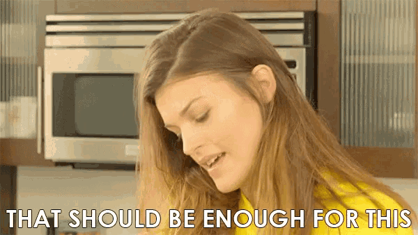 a woman in a yellow shirt says that should be enough for this in front of a microwave .