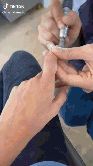 a person is getting their nails done by charlidamelio on tik tok