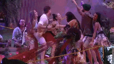 a group of people are dancing on a stage in front of a crowd of people .