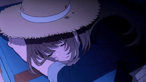 a girl wearing a straw hat is sleeping in a bed