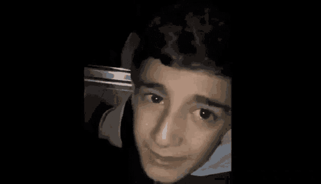 a young man is making a funny face while sitting in a car .