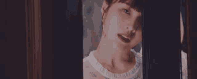 a close up of a woman 's face behind a door