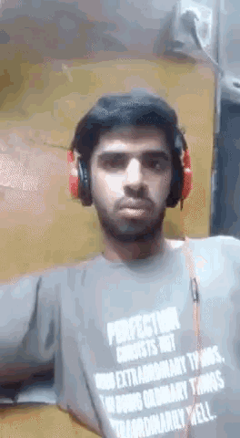 a man wearing headphones and a shirt that says " perfection consists not in extraordinary things "