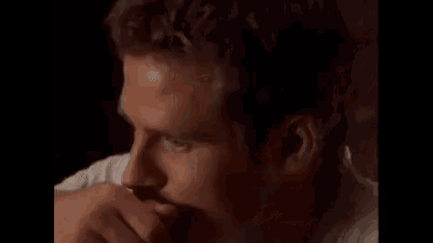 a close up of a man 's face in a white shirt looking at the camera .