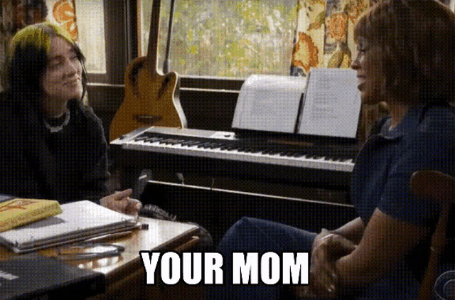 a woman is sitting at a table talking to another woman and the words your mom are visible