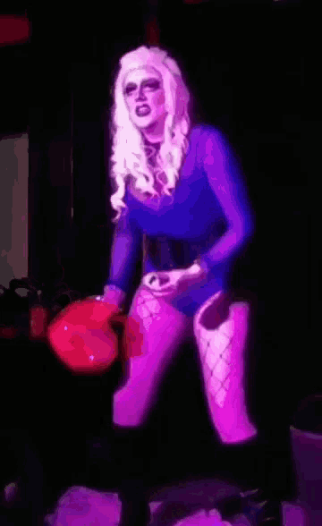 a woman in a purple bodysuit is holding a purple bag