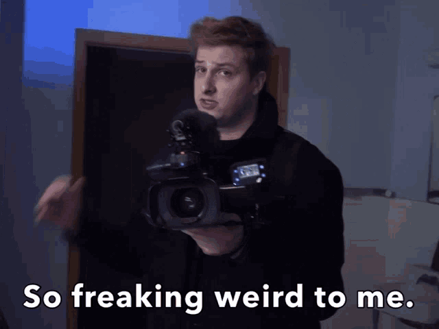 a man holding a camera with the words so freaking weird to me