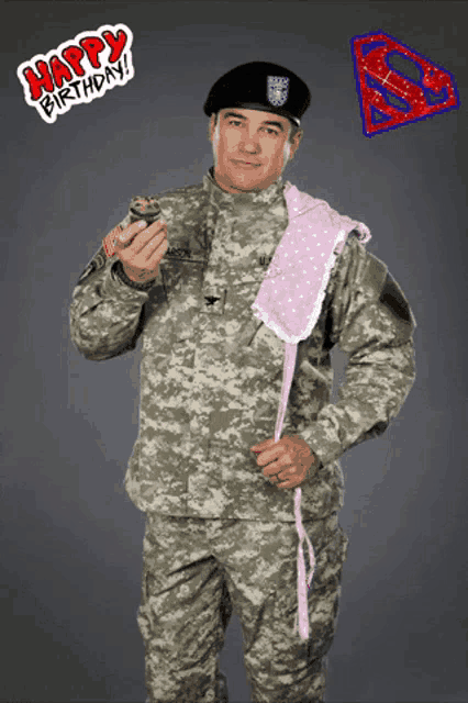 a man in a military uniform is holding a cupcake with a happy birthday sticker