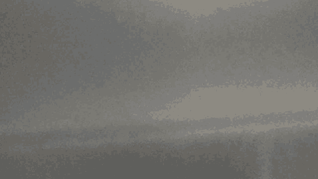 a close up of a gray surface with a few spots of light on it