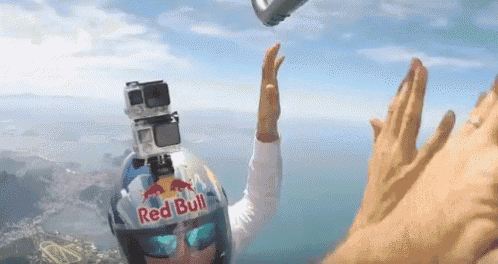 a person wearing a red bull helmet is in the air